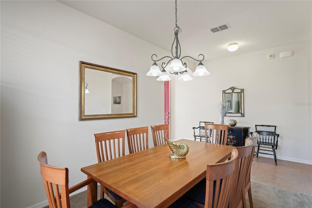 dining space with light tile patterned floors and a chandelier