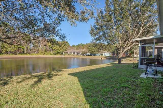 view of yard with a sunroom and a water view