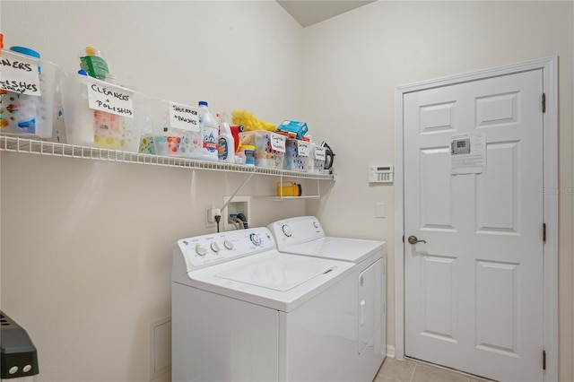 clothes washing area with light tile patterned floors and washer and dryer