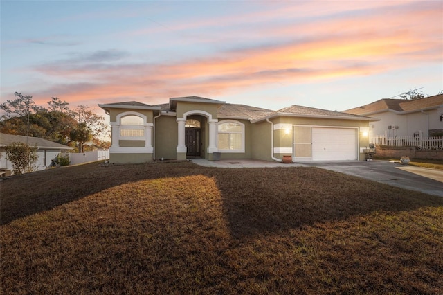 view of front of home featuring a lawn and a garage