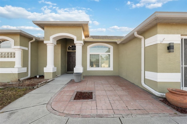 view of exterior entry with a patio