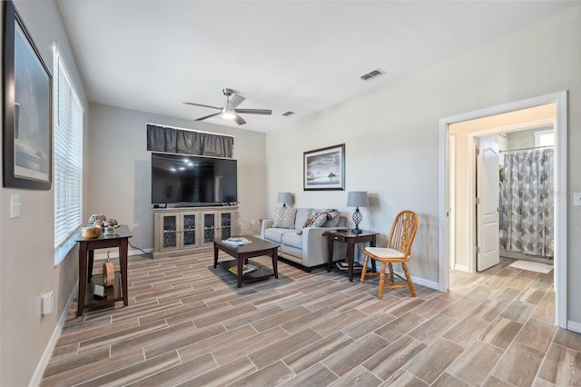 living room featuring a healthy amount of sunlight and ceiling fan