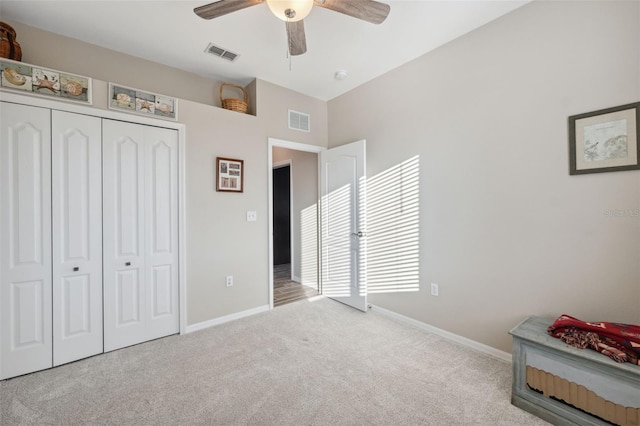 carpeted bedroom with ceiling fan and a closet