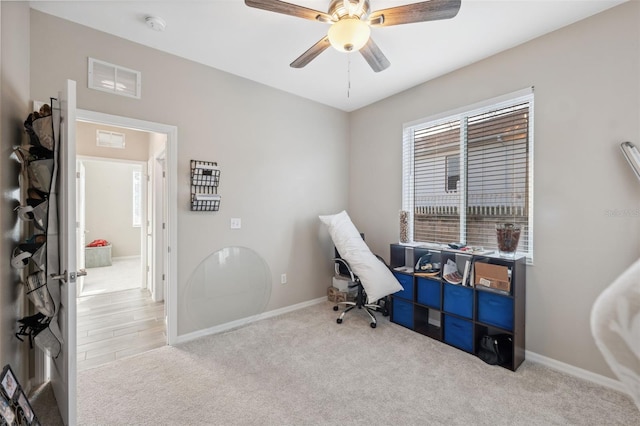 carpeted office space with ceiling fan