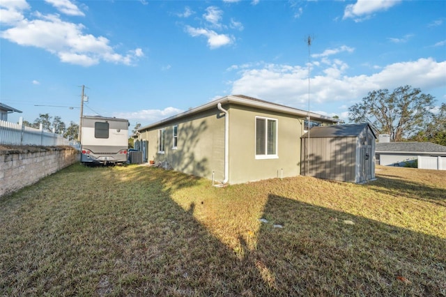 view of side of property with a lawn and a shed