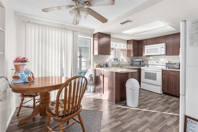 kitchen featuring ceiling fan, tasteful backsplash, white appliances, dark wood-type flooring, and dark brown cabinets