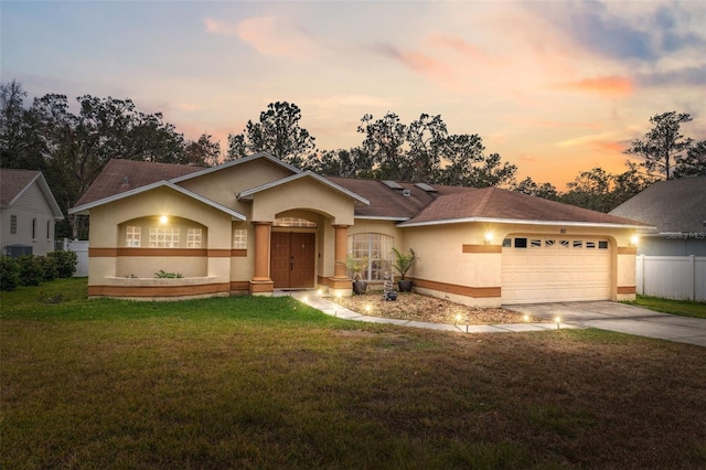 ranch-style home featuring a yard and a garage