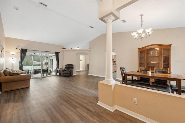 interior space featuring lofted ceiling, a notable chandelier, dark hardwood / wood-style floors, and ornate columns