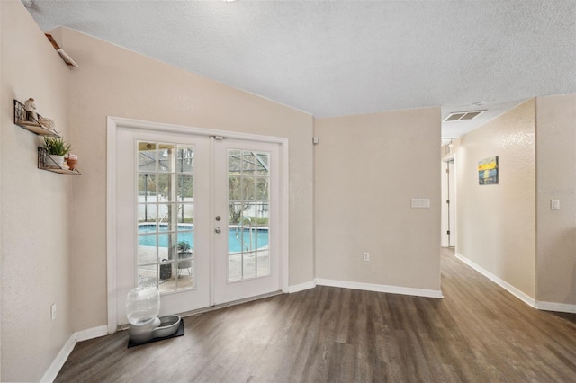 doorway to outside featuring french doors, dark hardwood / wood-style flooring, and a textured ceiling