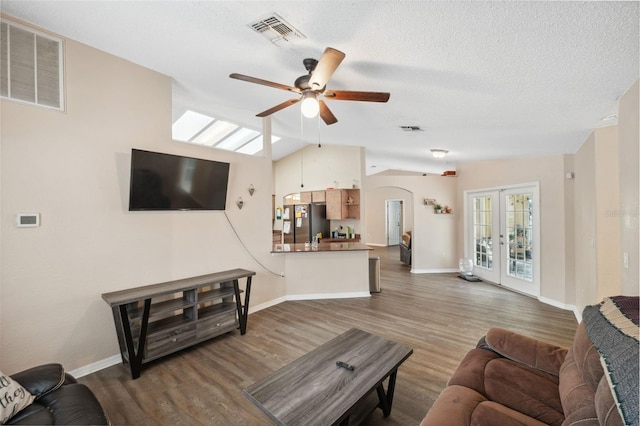 living room with ceiling fan, dark wood-type flooring, french doors, and vaulted ceiling