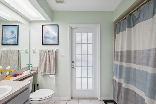 bathroom featuring toilet, a shower with shower curtain, vanity, and tile patterned floors