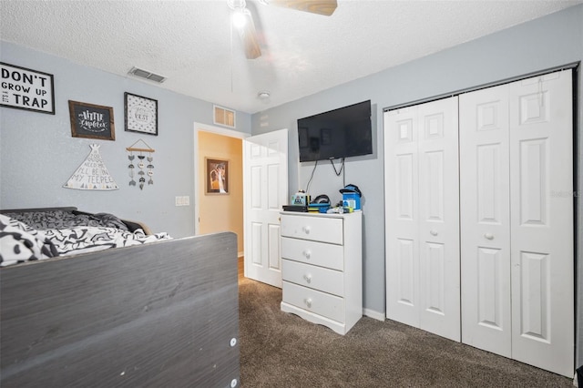 carpeted bedroom featuring ceiling fan, a closet, and a textured ceiling