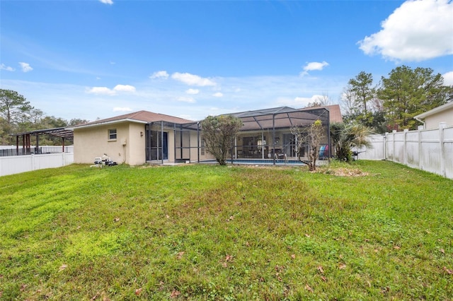 rear view of house featuring a lawn, a lanai, and a fenced in pool