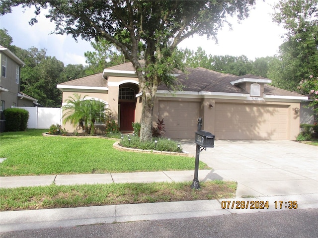 view of front of home featuring a front yard and a garage