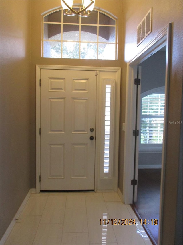 entrance foyer featuring tile patterned flooring and a notable chandelier