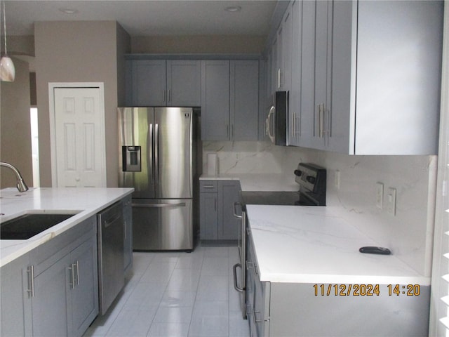 kitchen featuring gray cabinetry, sink, and appliances with stainless steel finishes