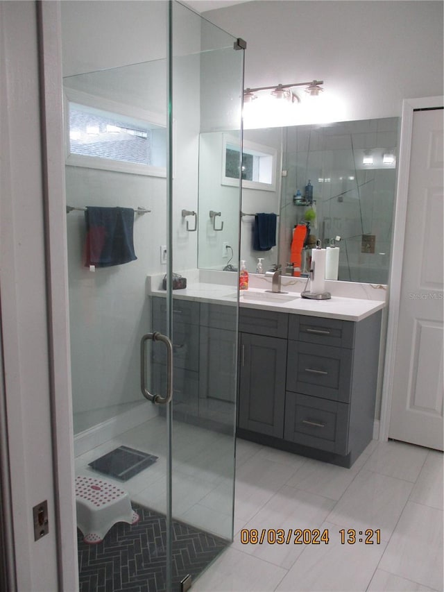 bathroom with tile patterned flooring, vanity, and a shower with shower door