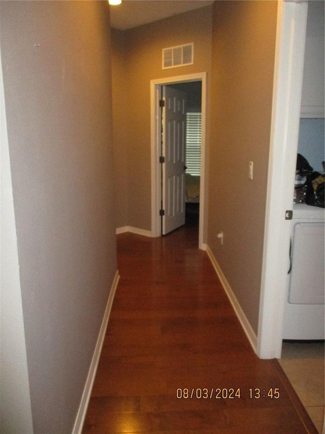 hallway with washer / clothes dryer and dark hardwood / wood-style floors