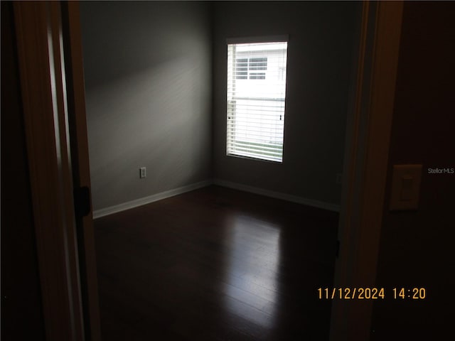 spare room with dark wood-type flooring