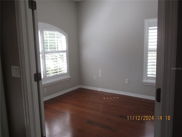 unfurnished room with dark hardwood / wood-style floors