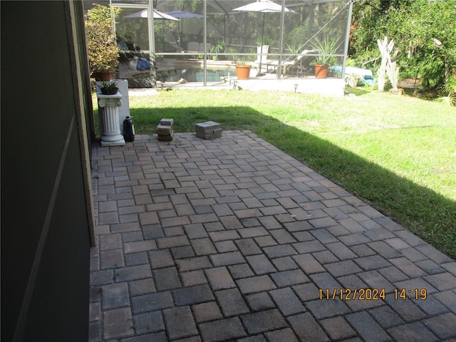 view of patio featuring glass enclosure