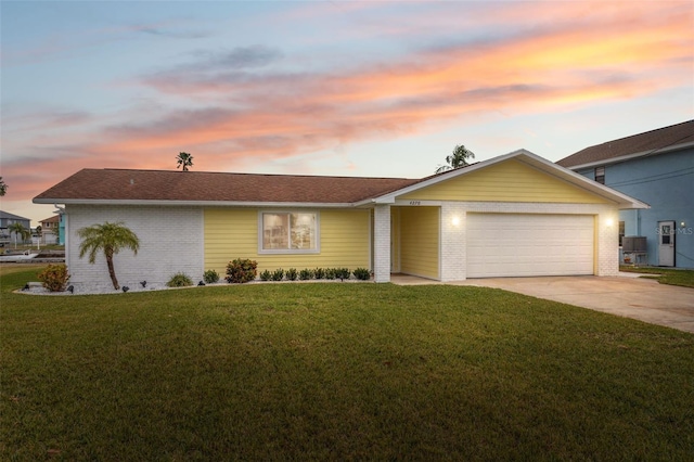 ranch-style home featuring a garage and a yard