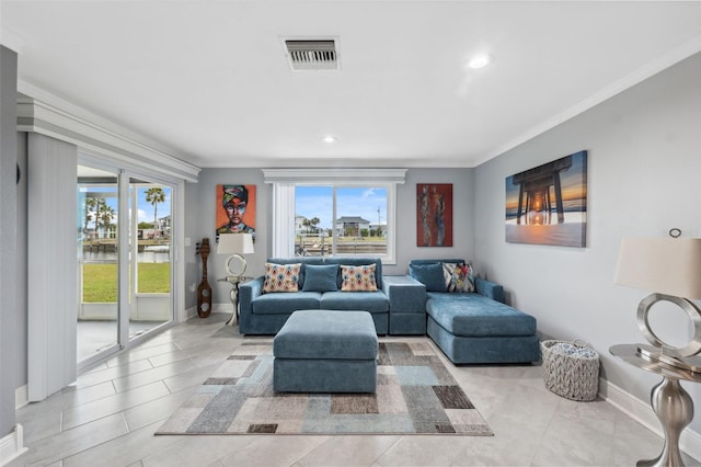 tiled living room featuring a healthy amount of sunlight and ornamental molding