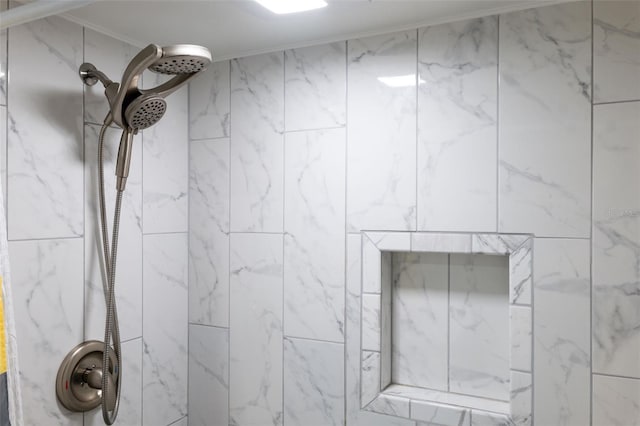 bathroom featuring ornamental molding and tiled shower