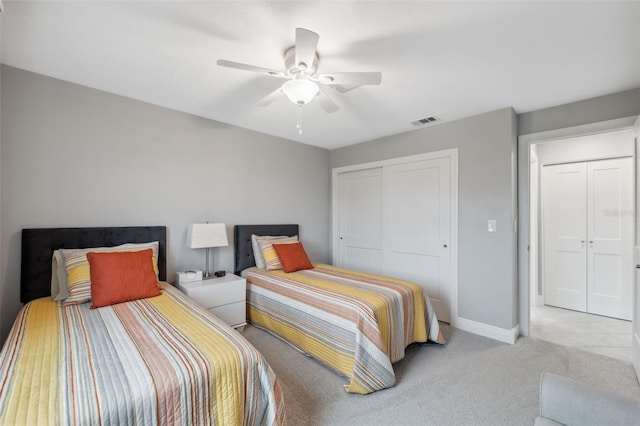 bedroom with ceiling fan, light colored carpet, and a closet