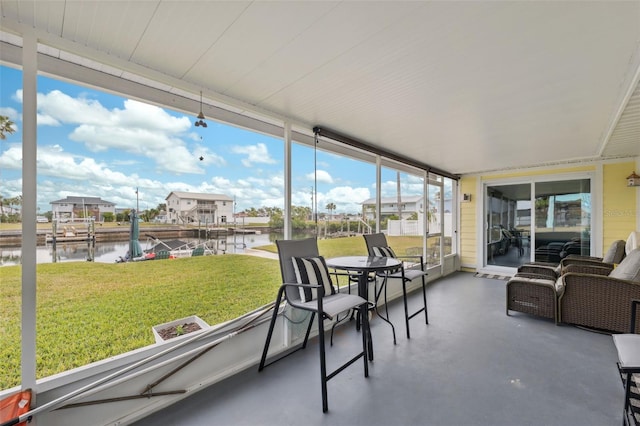 sunroom featuring a water view