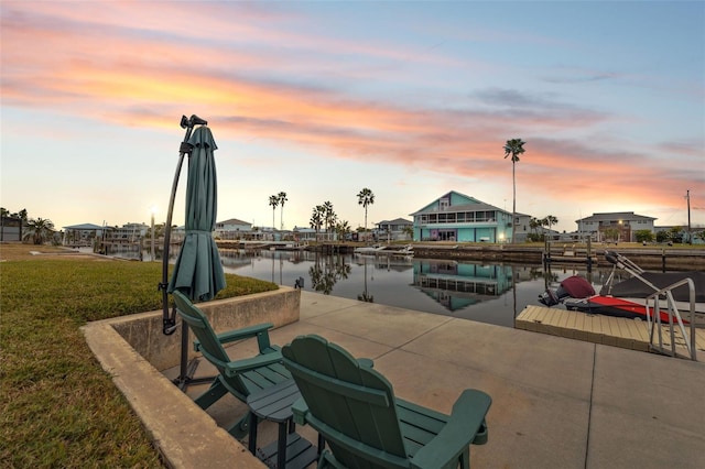 exterior space featuring a lawn, a boat dock, and a water view