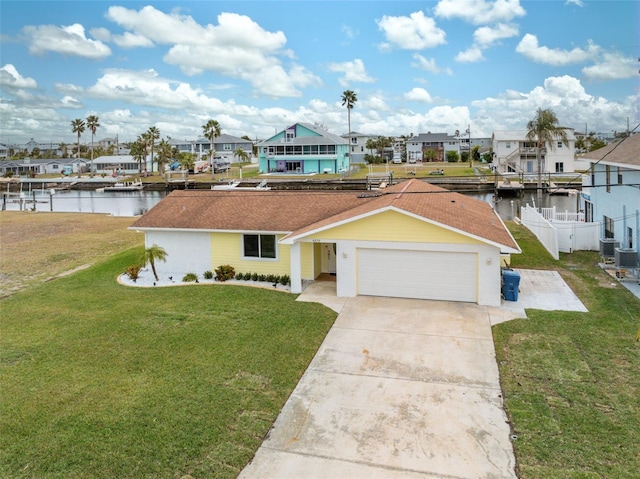 view of front of home with a garage, a front yard, and a water view