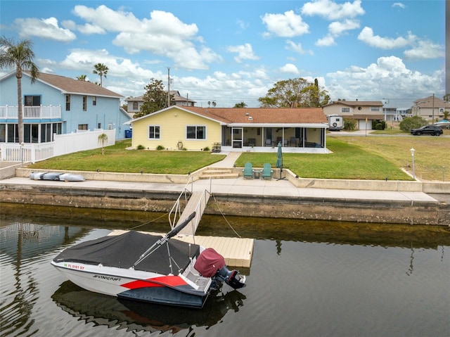 rear view of house featuring a lawn and a water view