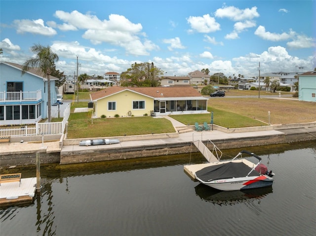 view of dock featuring a lawn and a water view