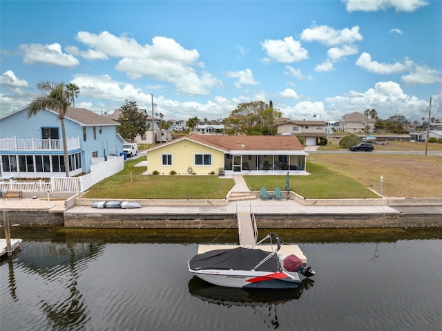 rear view of property with a water view and a lawn