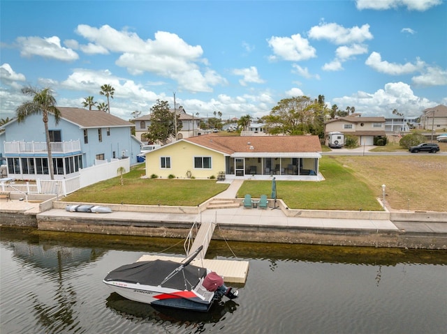 back of property with a yard and a water view