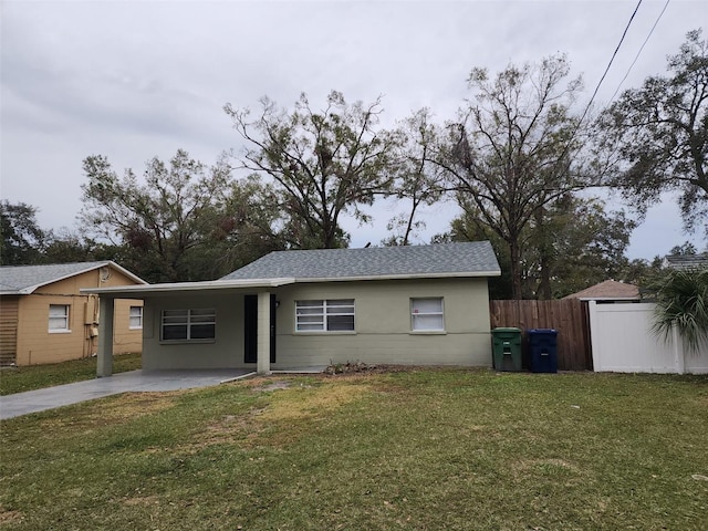 ranch-style house featuring a carport and a front lawn