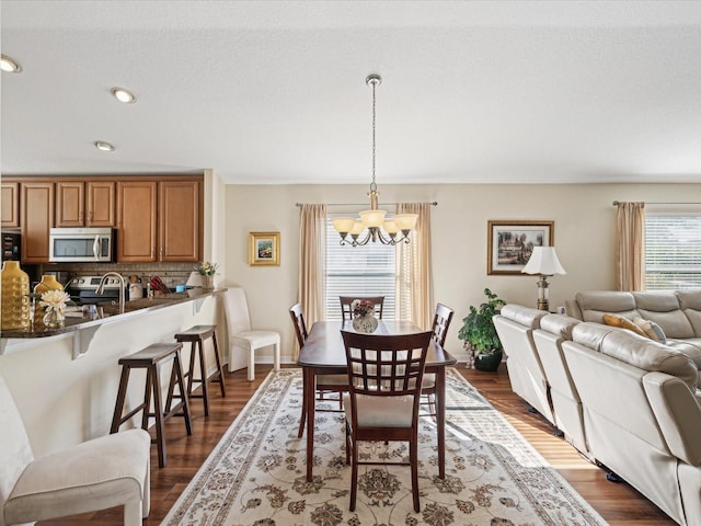 dining room with dark wood-type flooring and a chandelier