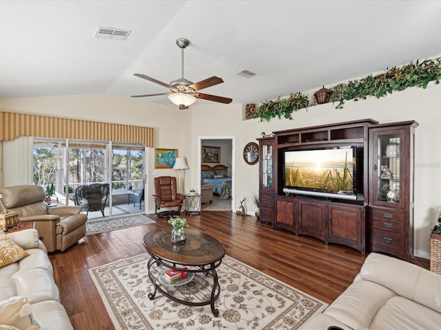 living room with ceiling fan, lofted ceiling, dark hardwood / wood-style floors, and a textured ceiling