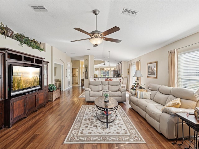 living room with lofted ceiling, dark wood-type flooring, a textured ceiling, and ceiling fan