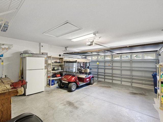 garage featuring white fridge, electric water heater, and a garage door opener