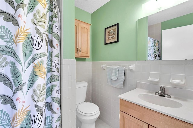 bathroom featuring toilet, a textured ceiling, tile walls, a shower with curtain, and vanity