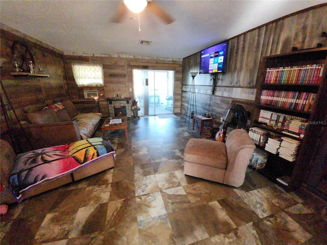 living room featuring ceiling fan and wooden walls