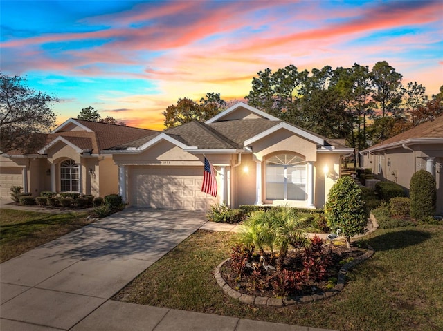 single story home featuring a garage and a lawn