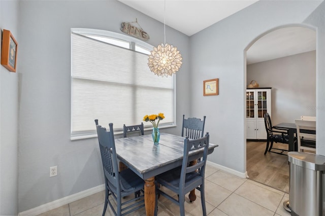 tiled dining room with an inviting chandelier and a wealth of natural light