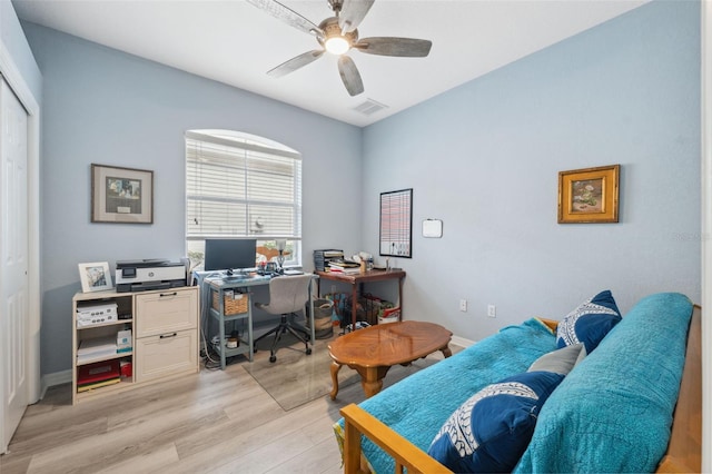 office with light wood-type flooring and ceiling fan