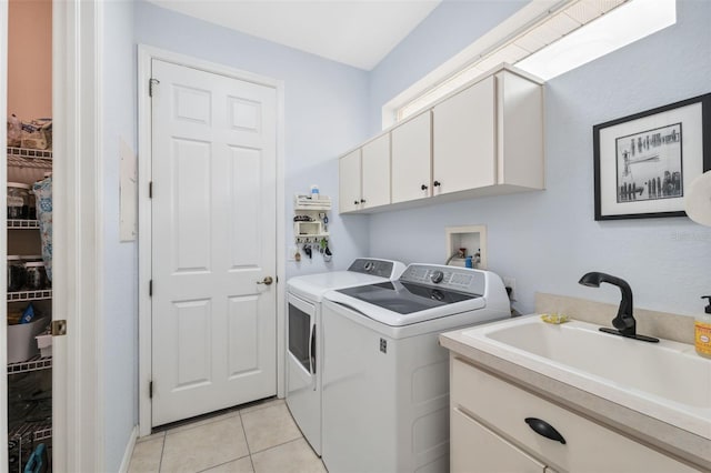 washroom featuring cabinets, light tile patterned floors, washer and clothes dryer, and sink