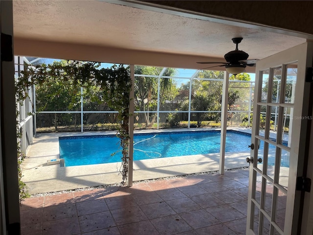 view of swimming pool featuring ceiling fan, a patio, and glass enclosure