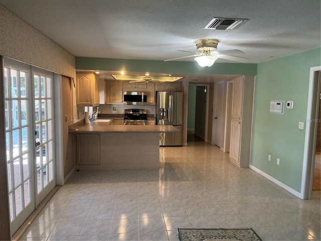 kitchen with kitchen peninsula, french doors, stainless steel appliances, ceiling fan, and sink