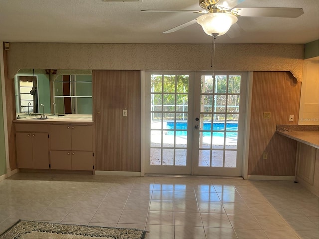 doorway to outside featuring ceiling fan, french doors, light tile patterned flooring, and sink